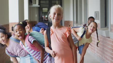 Video-of-happy-caucasian-girl-and-diverse-pupils-at-schoot-corridor