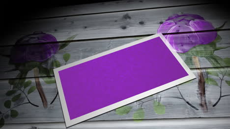 animation of purple card with copy space over purple flowers on wooden background