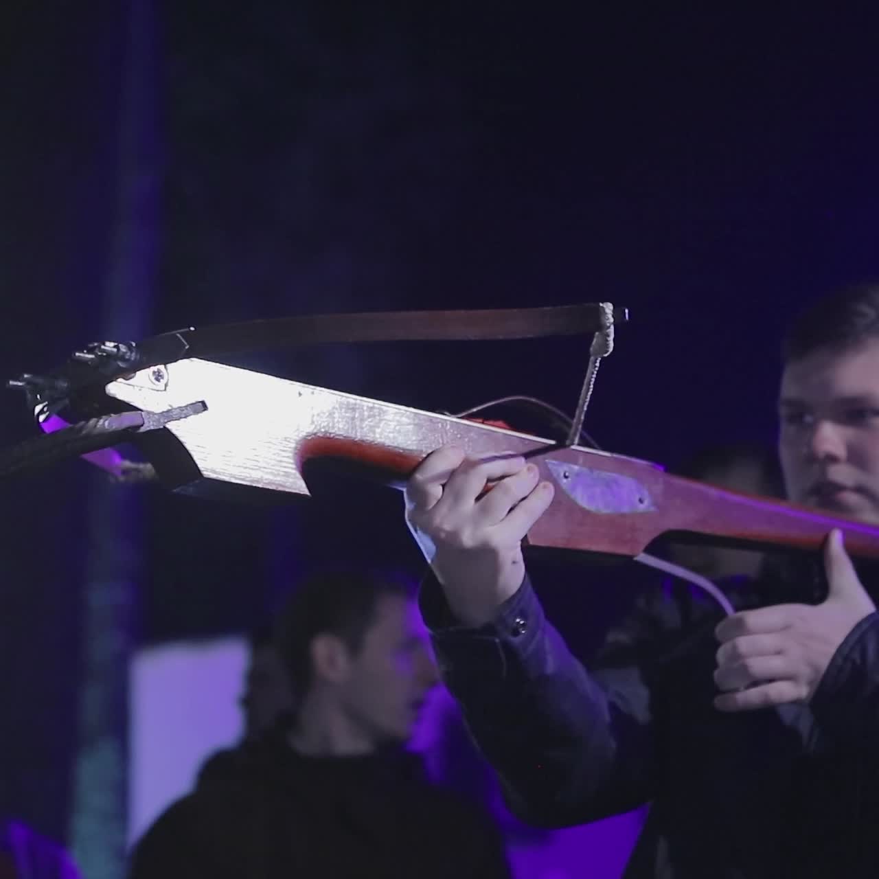 Man Aims A Crossbow At A Target