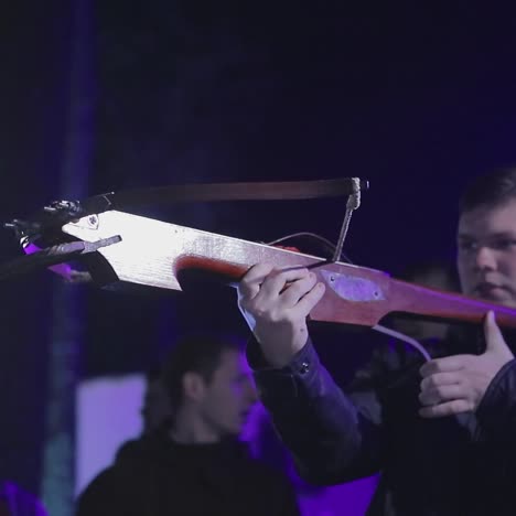 man aims a crossbow at a target