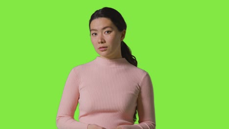 초록색 스크린 앞 에 서 있는 걱정 이나 불안 한 여자 의 스튜디오 초상화