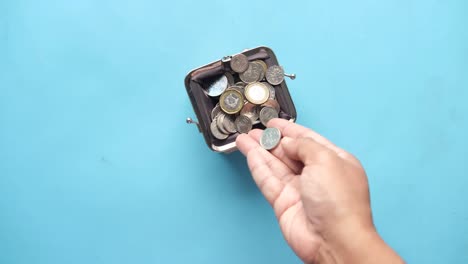 hand emptying coins from a small wallet