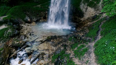 el hombre con barba está haciendo meditación de cascada bajo una gran cascada.