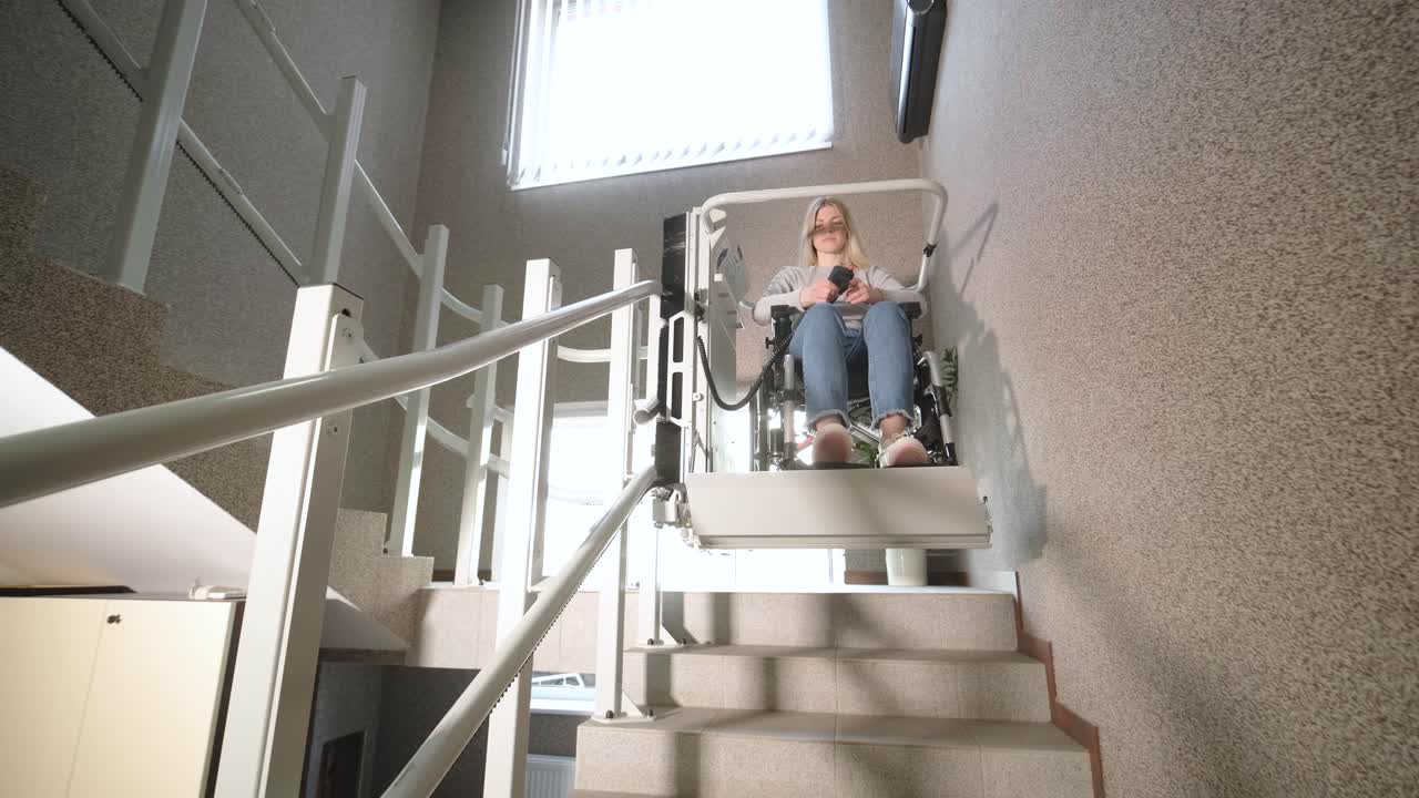 девушка в инвалидном кресле без труда поднимается по лестнице с помощью лестничного лифта.