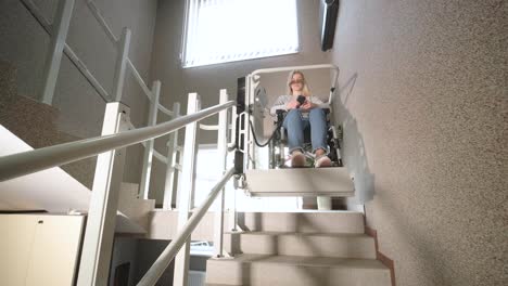 a girl in a wheelchair effortlessly ascends the stairs using a stair lift.