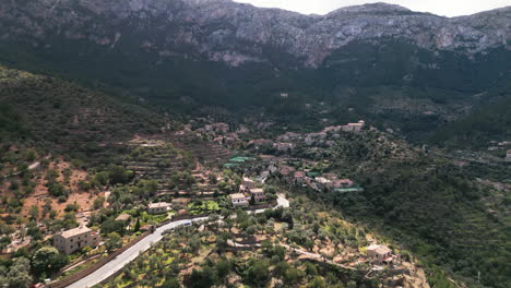 Vista-Aérea-Del-Pueblo-De-Deià-En-Mallorca-Con-Un-Pintoresco-Paisaje-Montañoso-Como-Telón-De-Fondo.