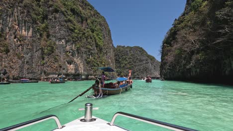 barcos turísticos navegando por las aguas esmeraldas entre acantilados