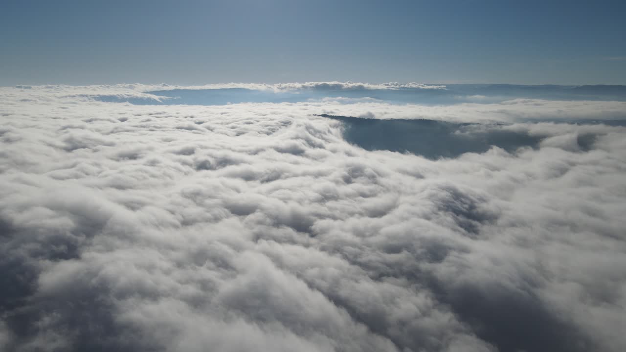 Drone view through cloudy sky, white puffy sky