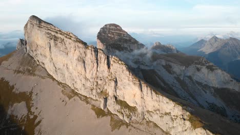 aerial flyover alongside tour d'aï and tour de mayen in leysin, vaud, switzerland during a colorful autumn afternoon in the swiss alps