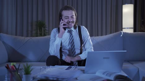 Cheerful-man-making-phone-call-at-home.