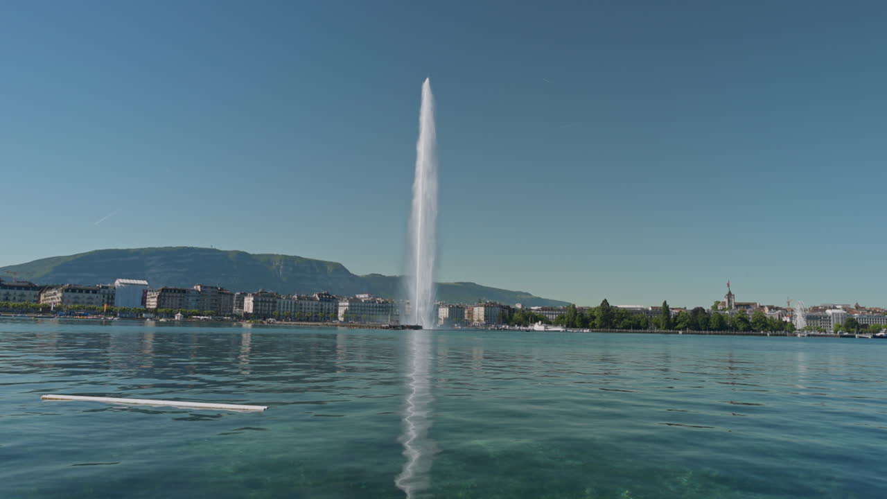 Peaceful morning in Geneva with the iconic Jet d’Eau rising from the lake, calm waters reflecting the clear sky, and the city slowly coming to life in the morning light.