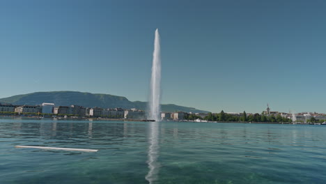 peaceful morning in geneva with the iconic jet d’eau rising from the lake, calm waters reflecting the clear sky, and the city slowly coming to life in the morning light.