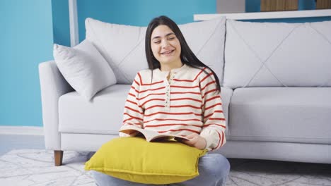 happy young woman reading a book at home and being happy.