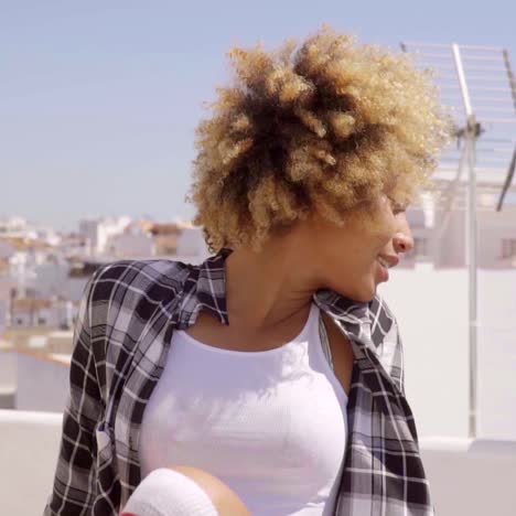 Young-Woman-with-Afro-Relaxing-on-Urban-Rooftop