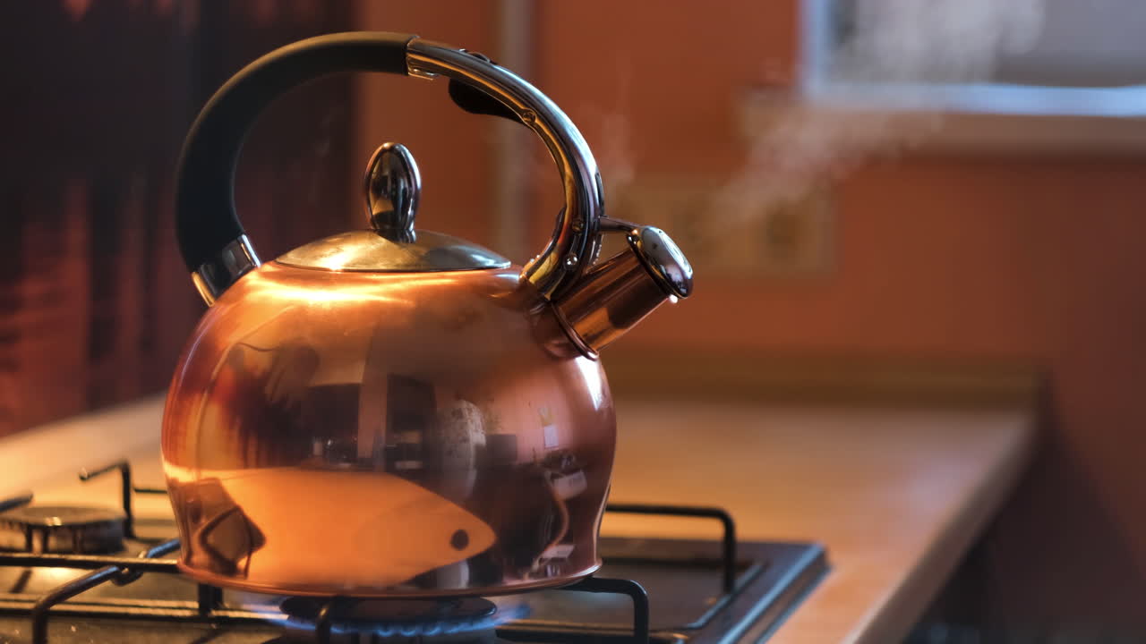 una tetera de cobre hirviendo en una estufa de gas