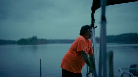 bearded man looking out on the lake at blue hour