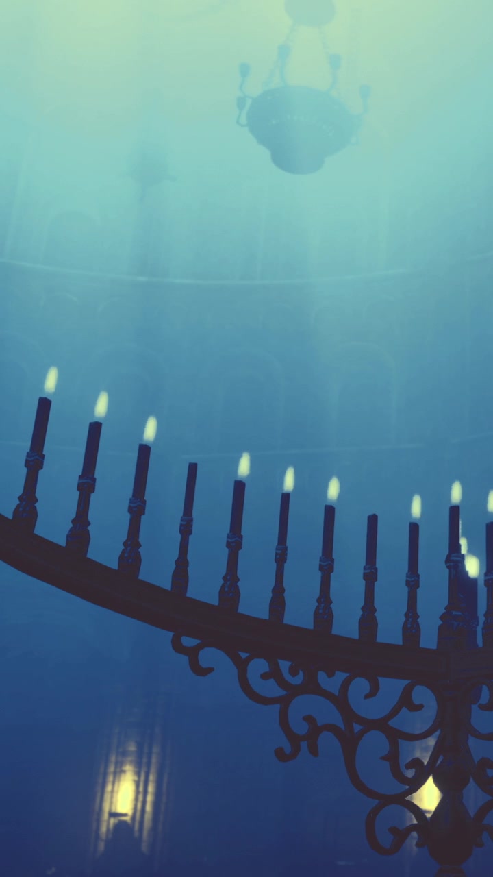 Candles glow in dark space with light rays coming from above