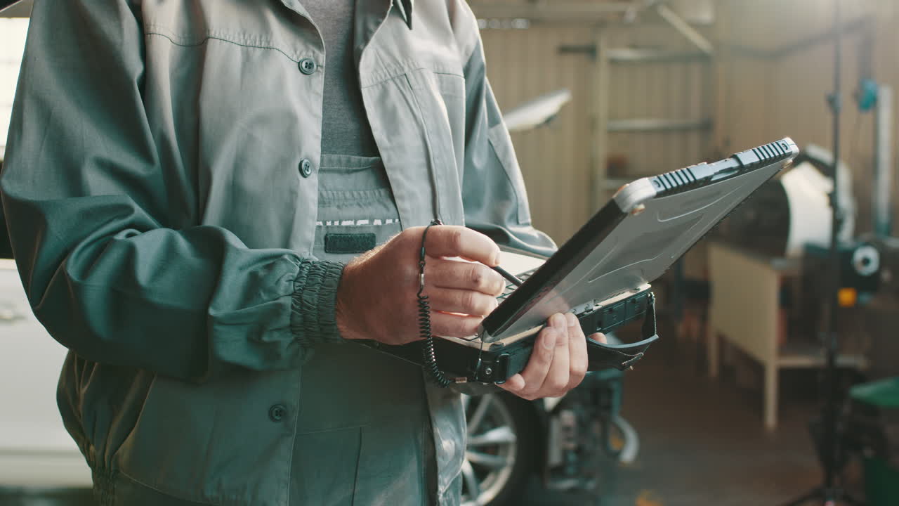 mecánico de automóviles usando una herramienta de diagnóstico en el garaje
