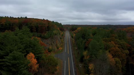 Vorwärtsantenne-Entlang-Der-Landstraße-Durch-Farbenfrohen-Hügeligen-Herbstwald