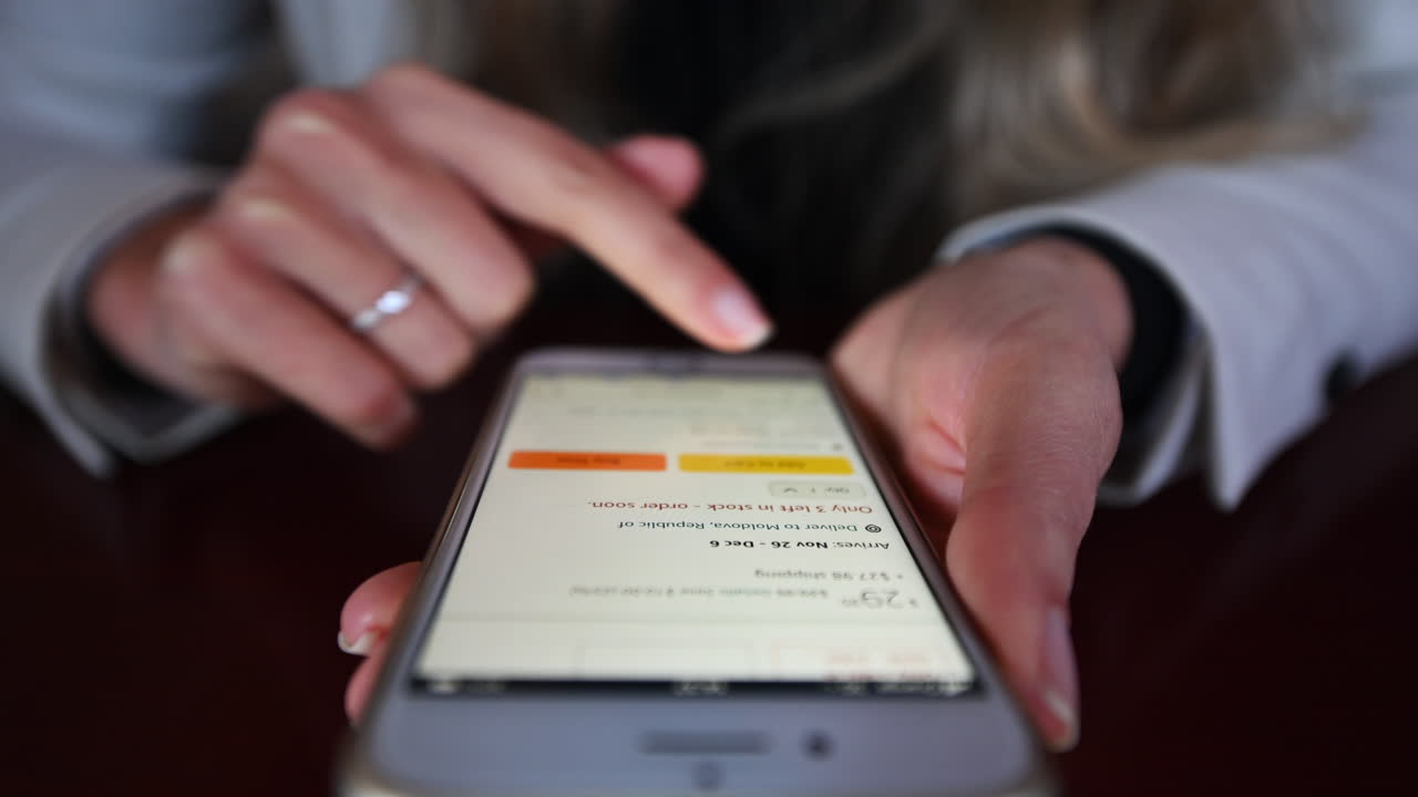 CHISINAU, MOLDOVA - NOVEMBER, 2021: Woman working on mobile phone in a restaurant at lunch