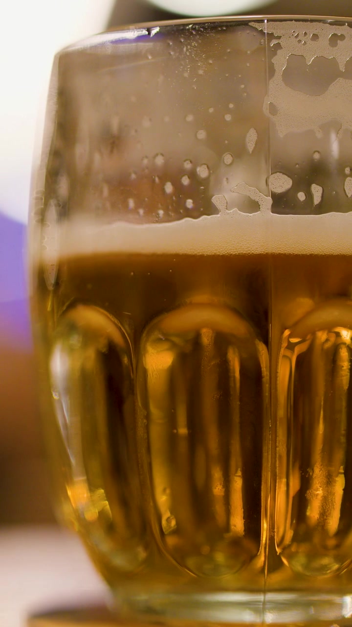 Primer plano de cerveza lager espumosa en una jarra de vidrio en una cervecería o pub checo.