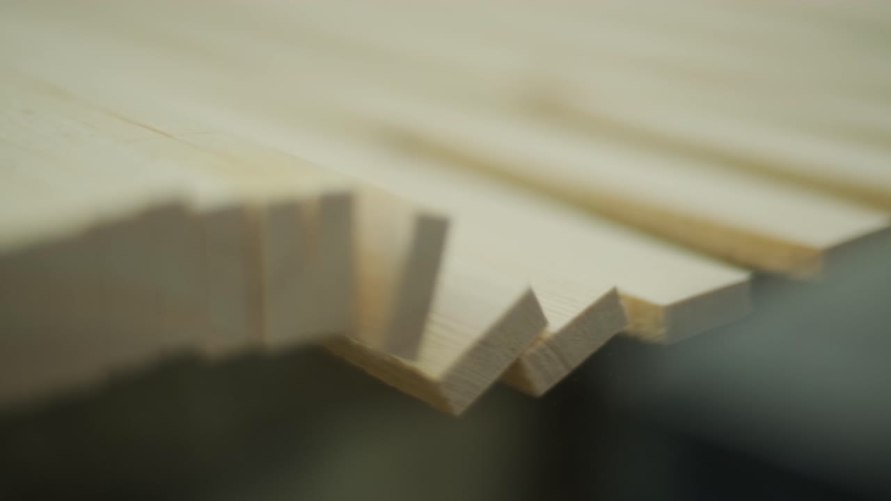 Primo piano di assi di legno in movimento su una linea di produzione.
