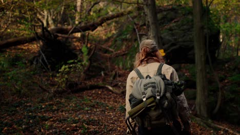 hiker walking in forest looking to sign direction, heading left, vogelberg