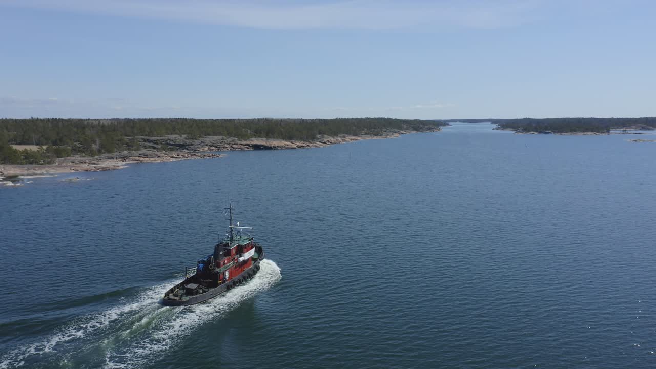 Idäntie tugboat KEMI 1 making way ahead in Finnish archipelago fairway. Aerial stern view.