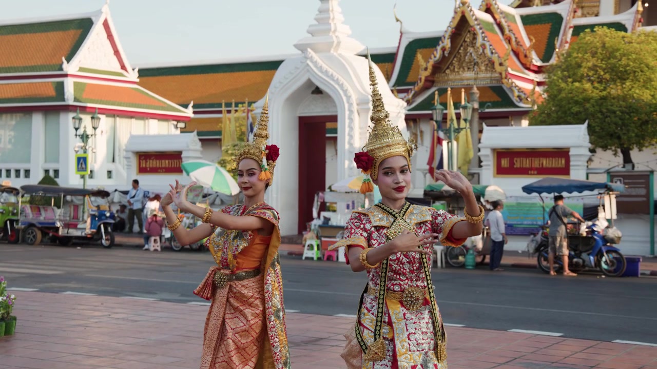 Ballerini thailandesi eseguono la tradizionale danza Khon indossando sontuosi costumi dorati fuori da un tempio di Bangkok.