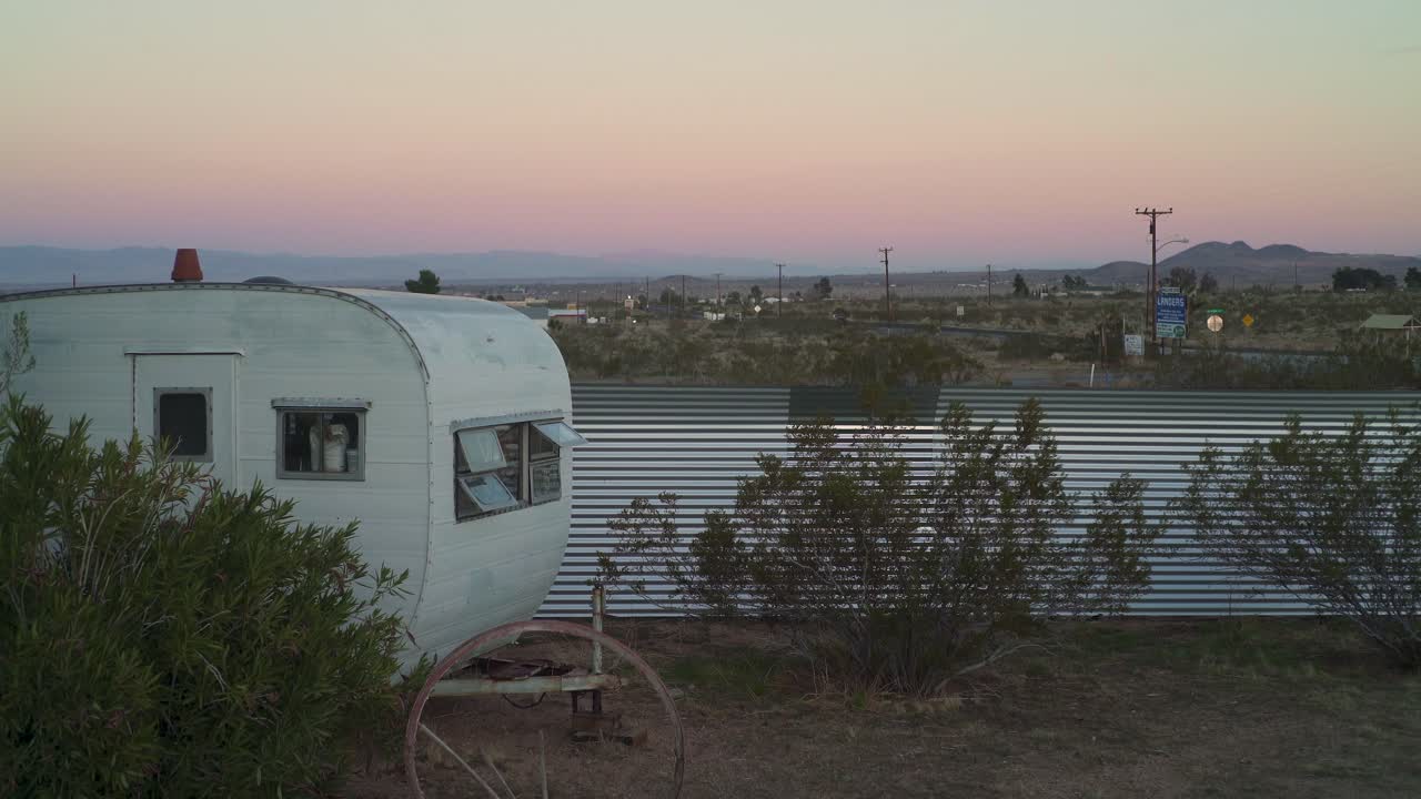 해가 지고, 사막에서 어두워지는 오래된 레트로 캠퍼와 마차 바 ⁇
