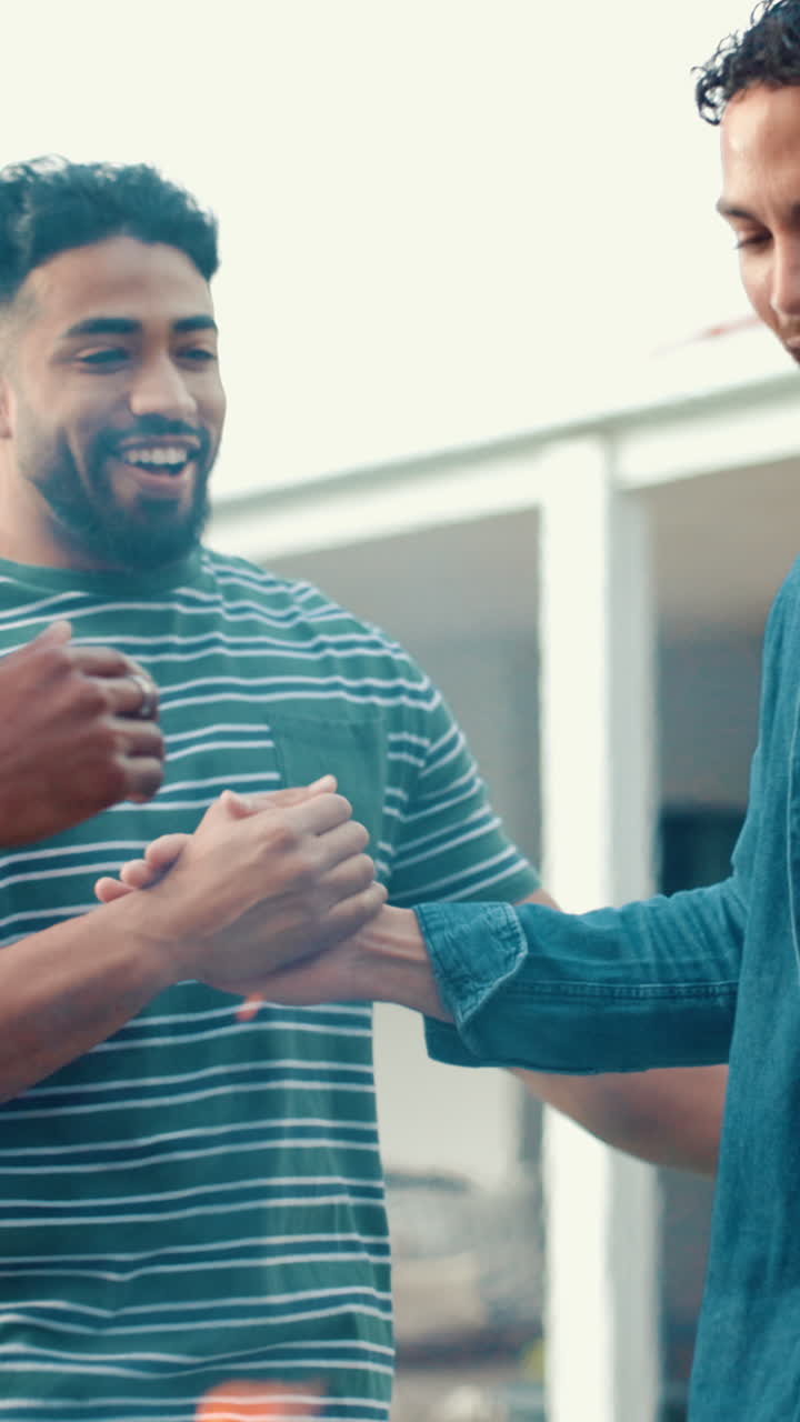 Due uomini felici si stringono la mano e ridono all'aperto