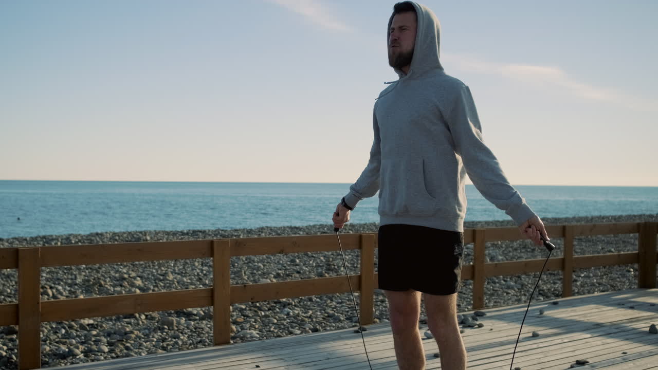 해변에서 로프를 뛰어넘는 남자