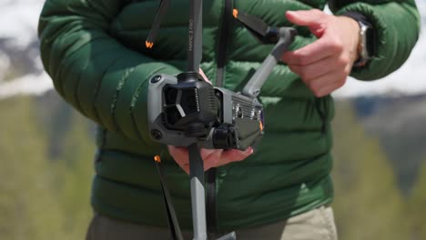 close up drone pilot unfolds a camera drone in preparation for flight