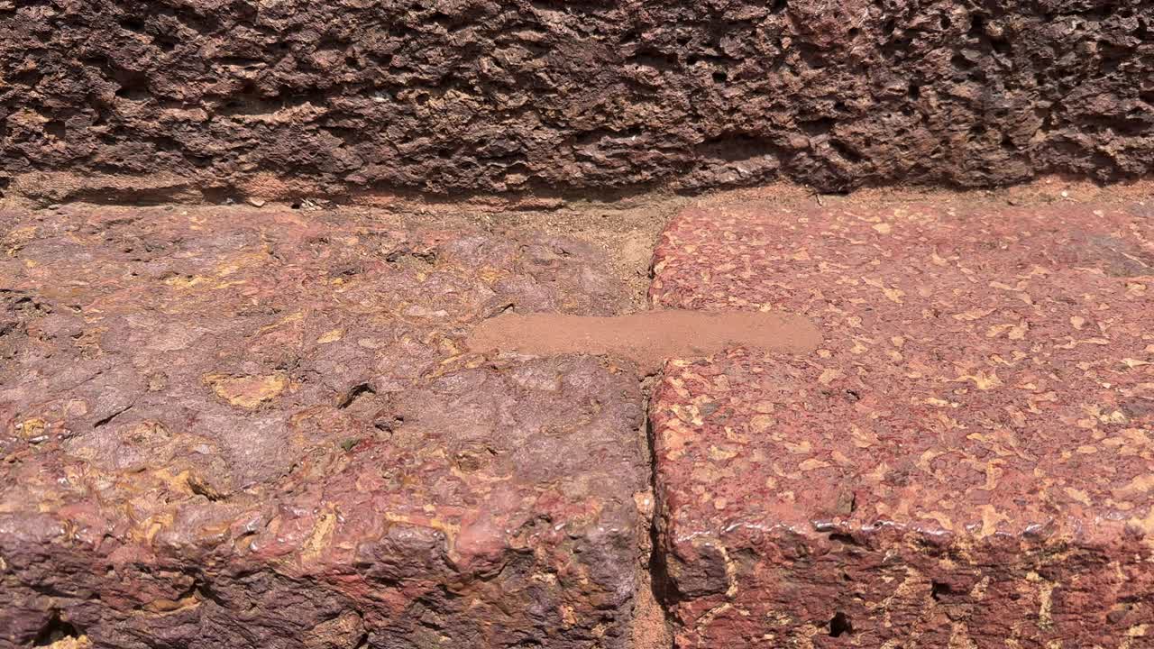 Tracking shot of a metal link between two stones an old technology used in the binding two stone structure