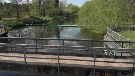drone clip of running water from a small river over a small concrete damm in thetford england