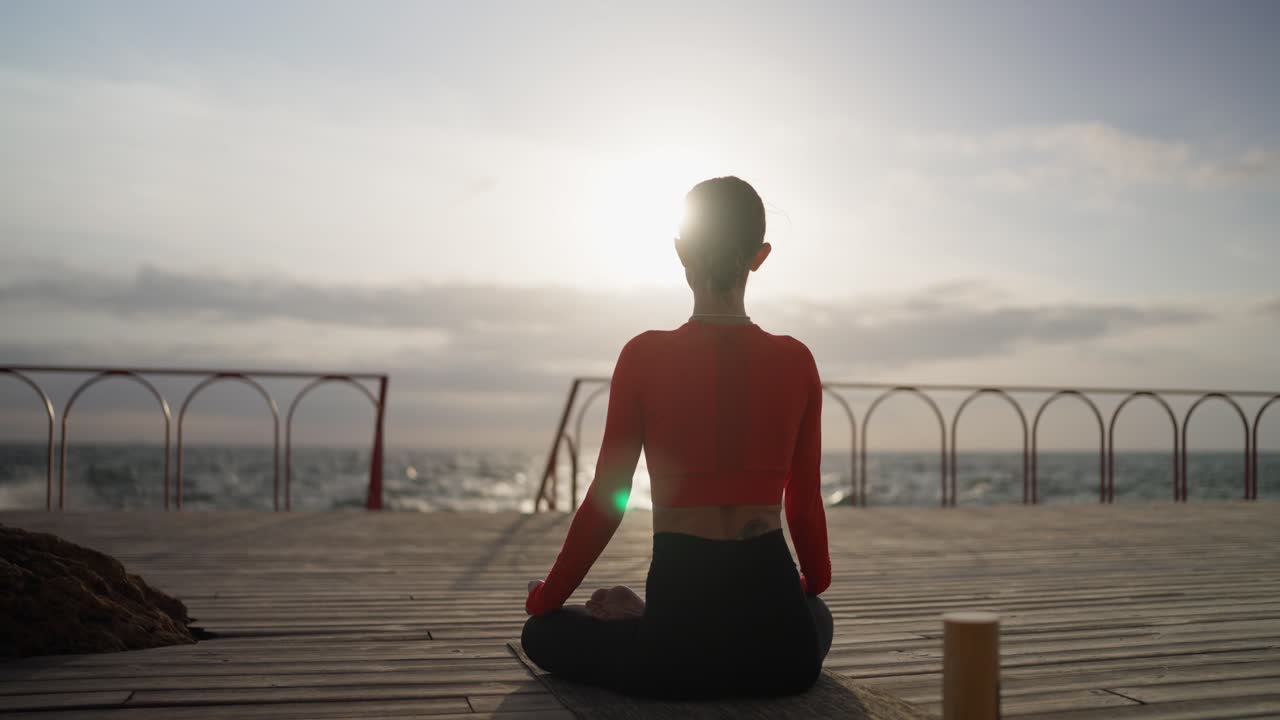 mujer meditando al amanecer en la playa