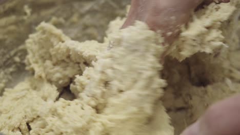 extreme close-up of a baker's hands mixing dough