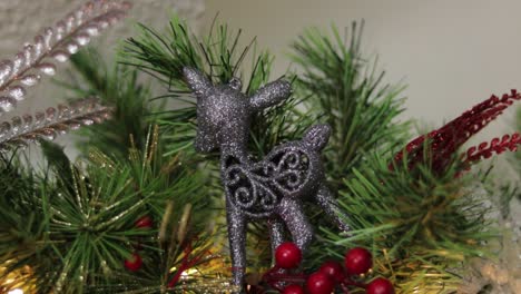ornamento navideño de brillo gris en agujas de pino decoradas