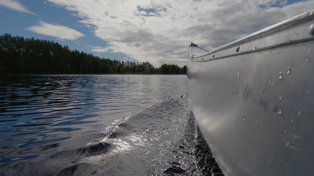 푸른 흐린 하늘이 있는 큰 호수에서 스웨덴 호수 카약 보트를 타고 물 속을 여행하는 카누의 cu 보기