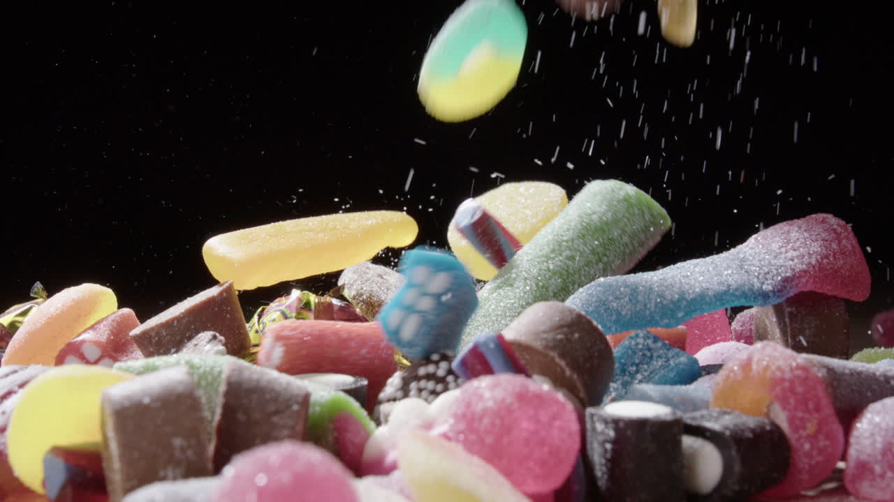 variedad de caramelos dulces azucarados cayendo en un montón, ángulo bajo slomo vista lateral