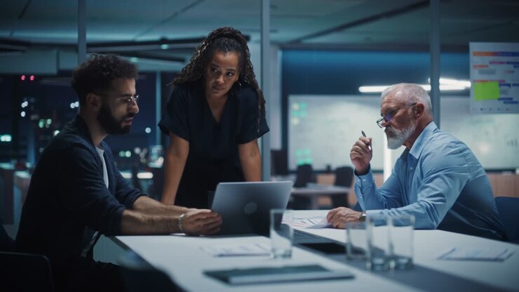 Office Conference Room Meeting: Diverse Team of Top Managers Talk, Discuss, Brainstorm, Use Laptop Computer. Business Partners Presenting Investment and Marketing Strategy for E-Commerce Startup.