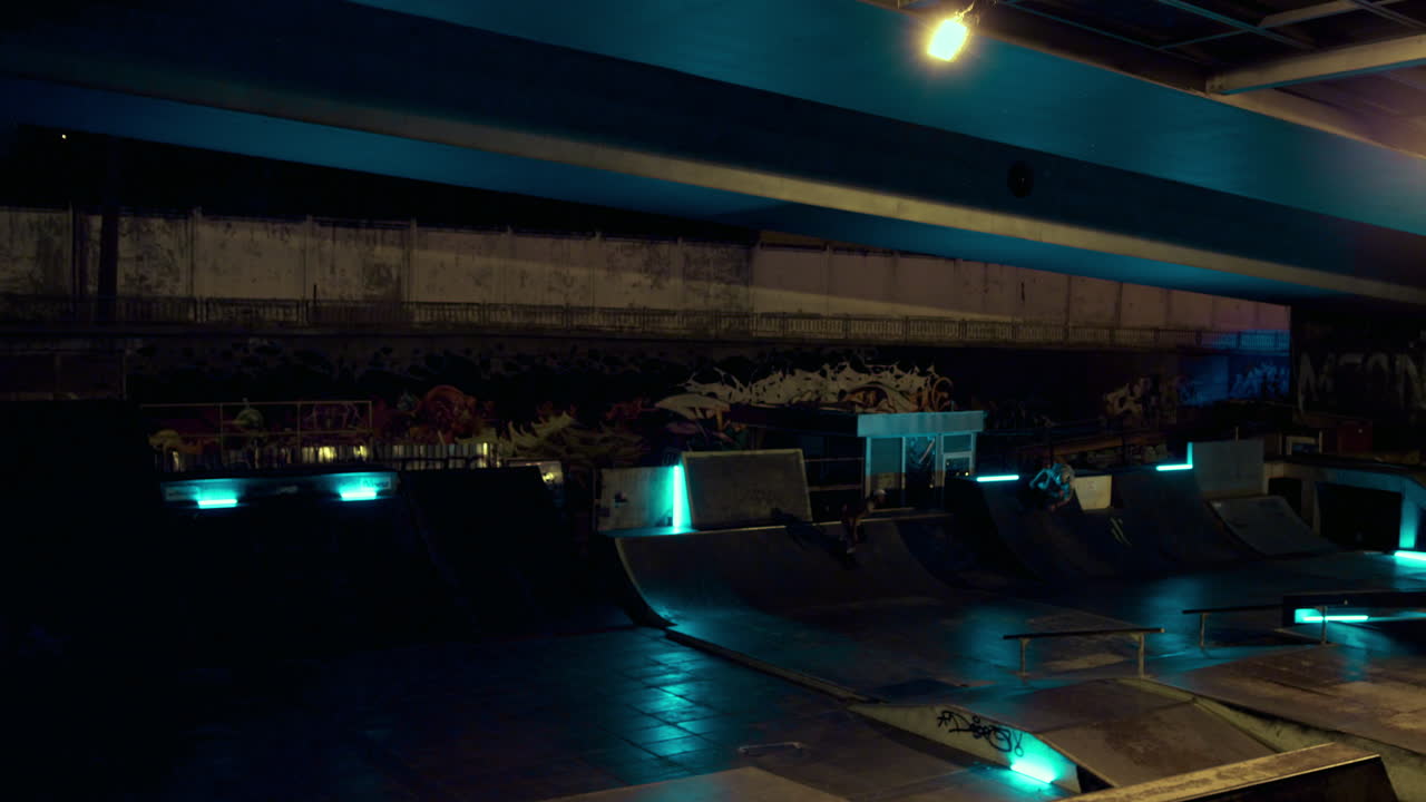 익스트림 bmx 바이커가 야외에서 밤에 자전거를 타고 램프에 뛰어들고 있습니다.