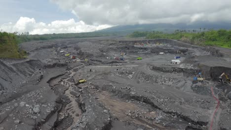 Aerial-view-of-vehicles-moving-along-a-new-roadway-through-the-destruction-left-behind-after-a-volcanic-eruption-of-Mount-Semeru,-East-Java-Indonesia