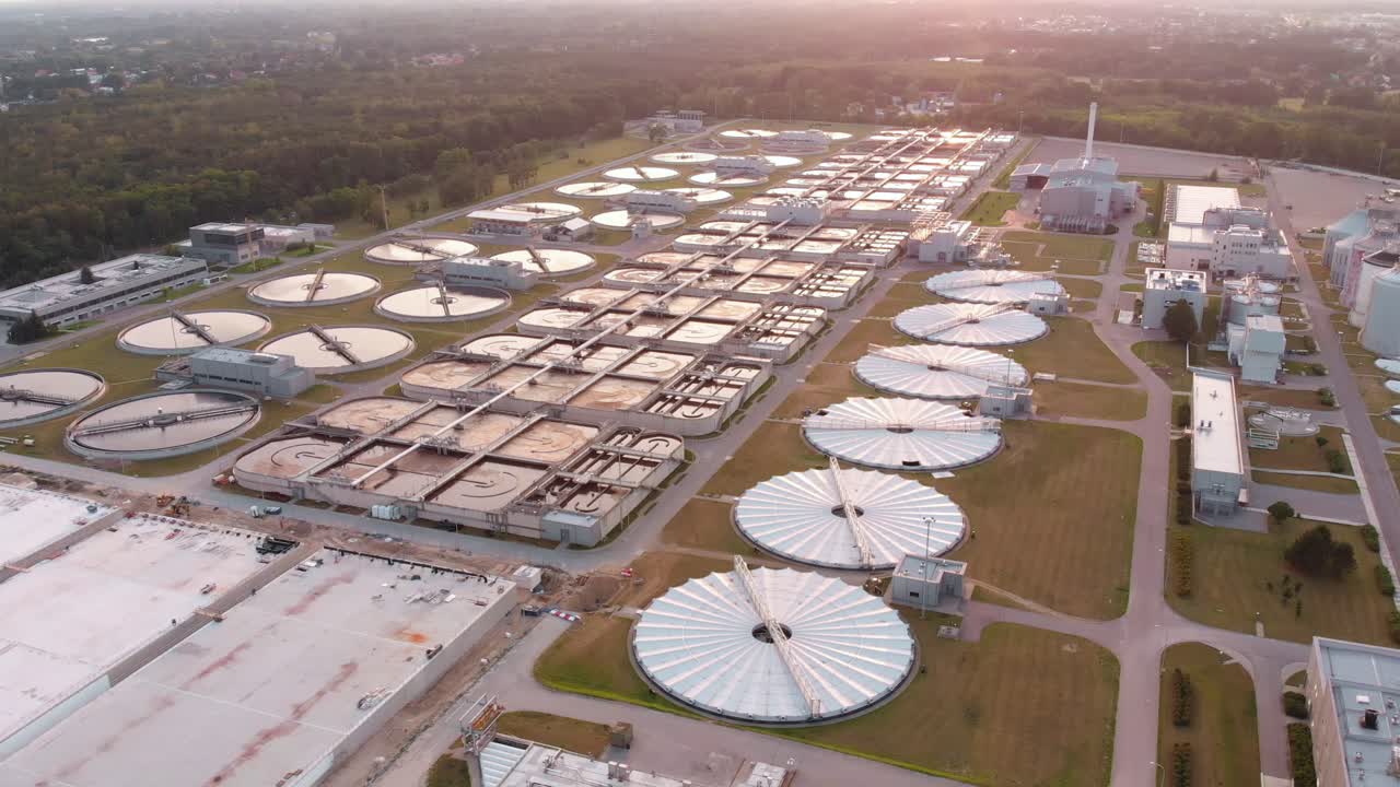 Aerial establishing shot over a large wastewater treatment plant at sunset