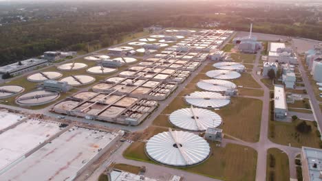 Aerial-establishing-shot-over-a-large-wastewater-treatment-plant-at-sunset