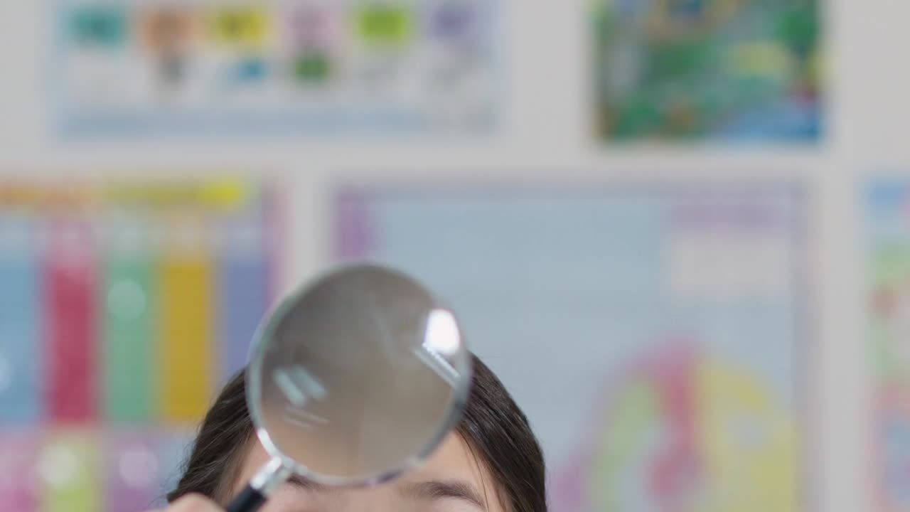 三つ編みの髪をした好奇心旺盛な女子学生が、教室で虫眼鏡を使って物を調べています。