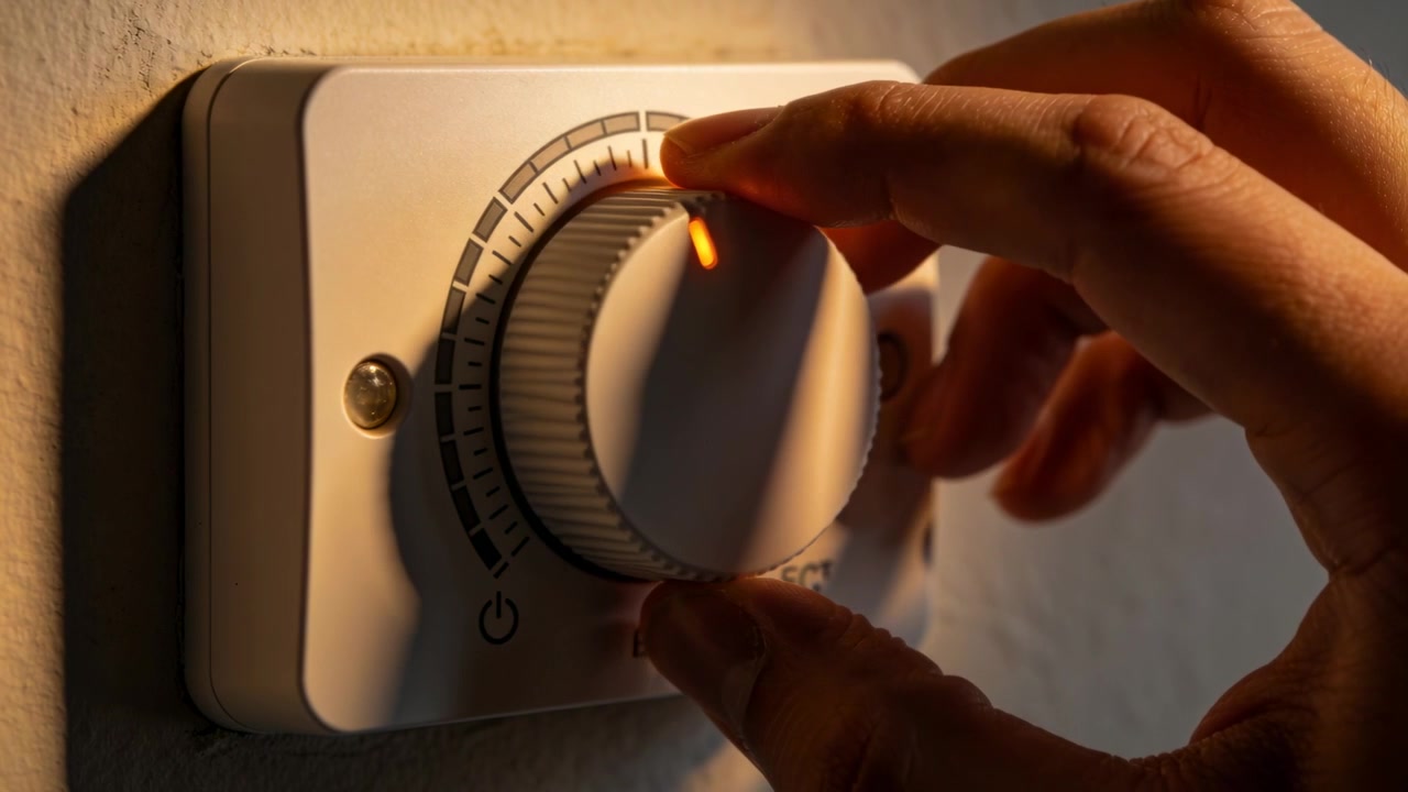 Entering right hand grasping knob in room, moving orange indicator along scale, adjusting control