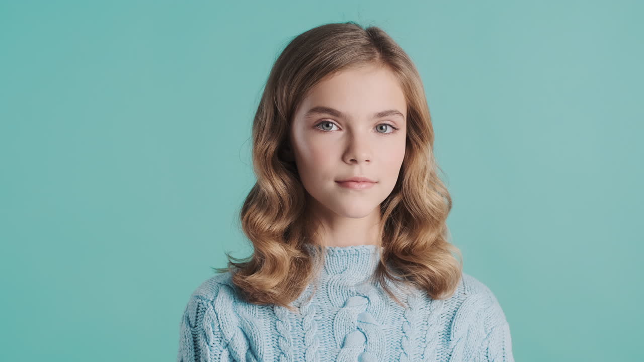 십대 백인 소녀가 카메라를 쳐다보고 있습니다.