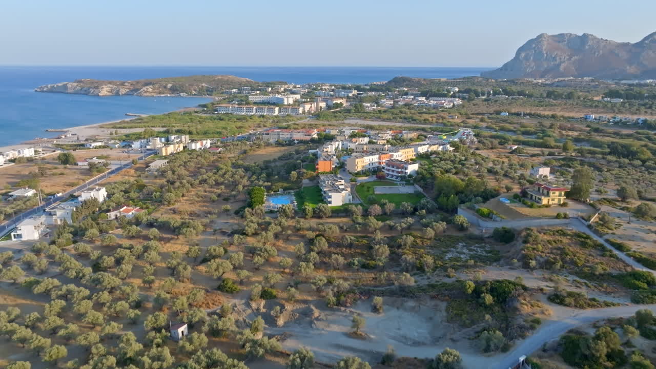 Establishing drone shot tilting toward the Kolymbia town, golden hour in Rhodes