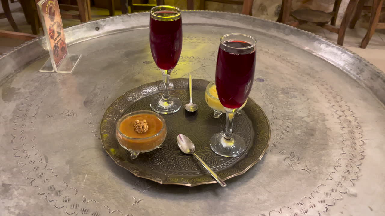 Turkey, Mardin, Traditional sweets presentation with syrups by the side in a sweets shop at Mardin. Dessets on an traditional copper tray on a copper traditionally decorated tray table.